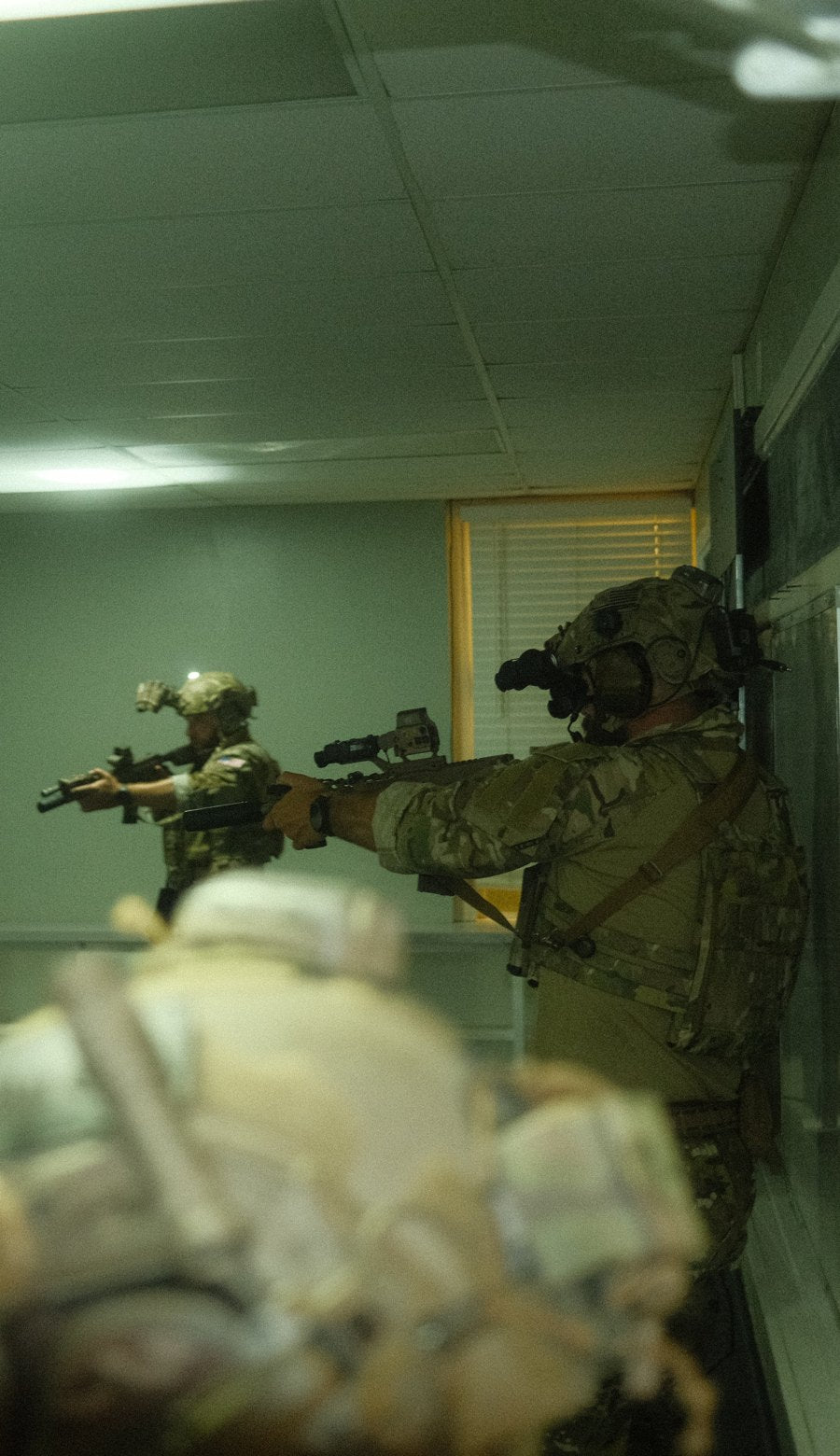 Team clearing a room with suppressed rifles