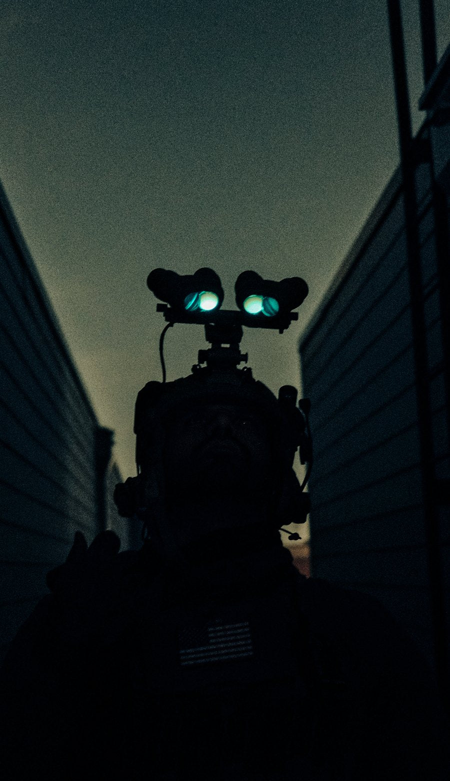 Operator silhouetted in an alley with glowing night vision
