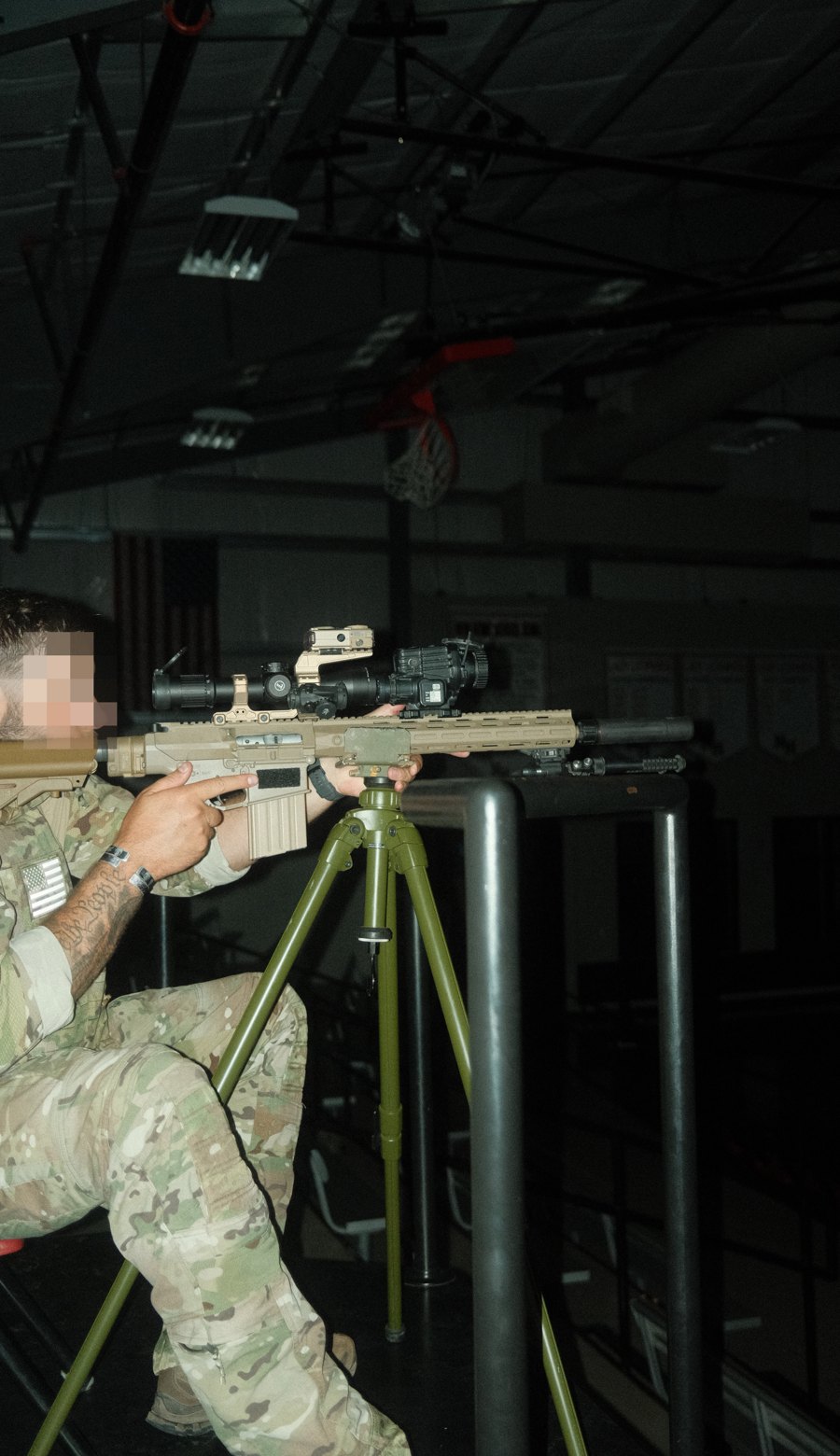 Shooter on a tripod-supported precision rifle with thermal clip-on